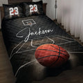 Black basketball quilt blanket displayed on a bed with court lines, hoop artwork, and a large orange basketball