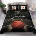 Basketball quilt bedding styled in a bedroom with black court artwork, hoop, and orange basketball design