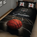 Close bedroom view of a black basketball quilt blanket with court lines, hoop, and orange basketball artwork