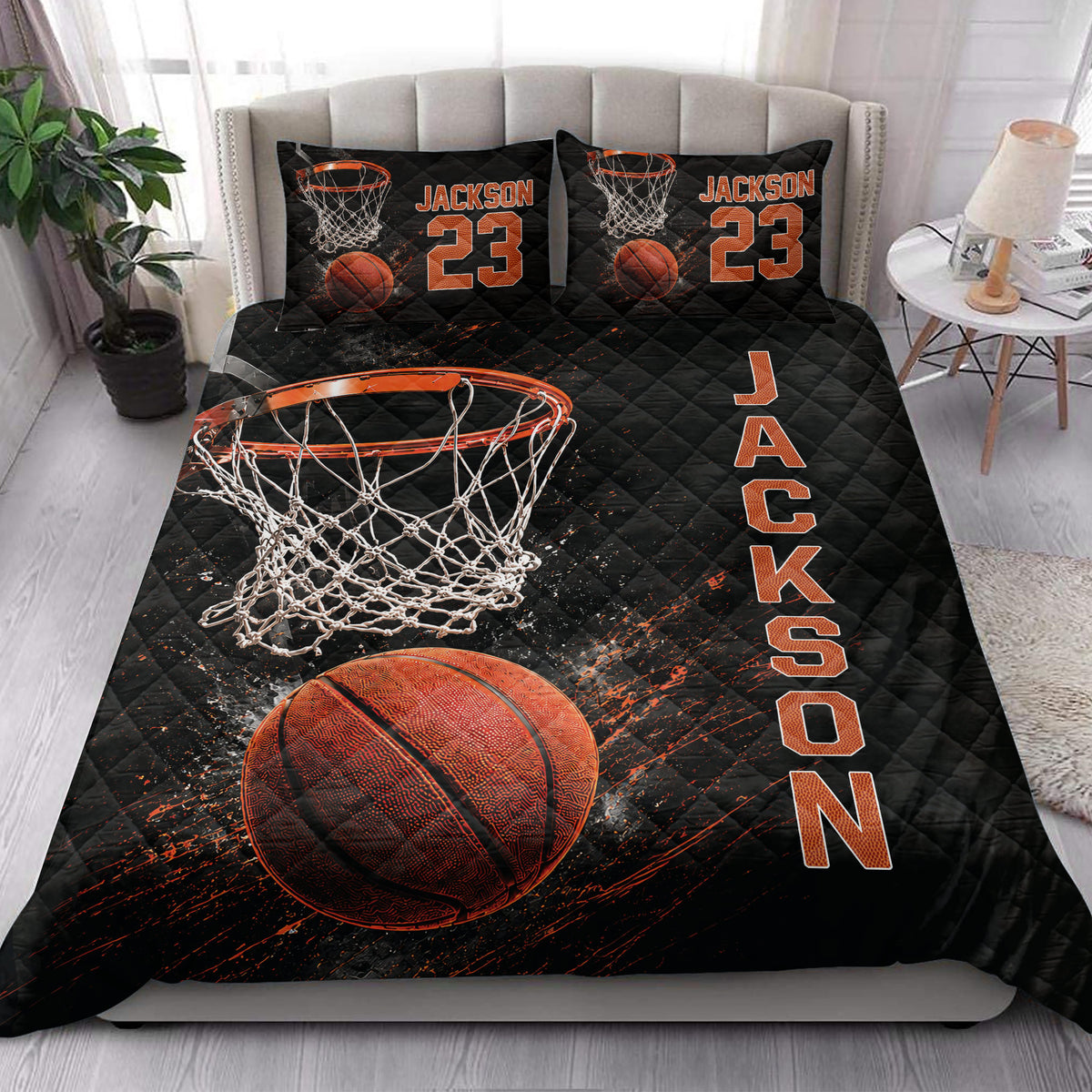 Basketball quilt blanket styled on a bed in a bright bedroom with black and orange sports artwork