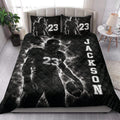 Football quilt blanket styled on a bedroom bed with dramatic black and white player artwork