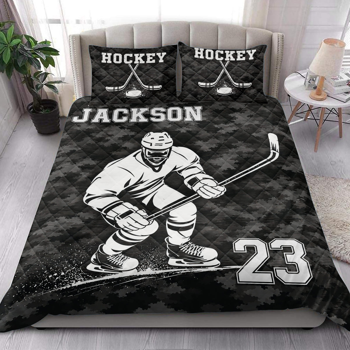 Hockey quilt blanket styled on a bedroom bed with a skating player, hockey sticks, puck, and bold monochrome artwork