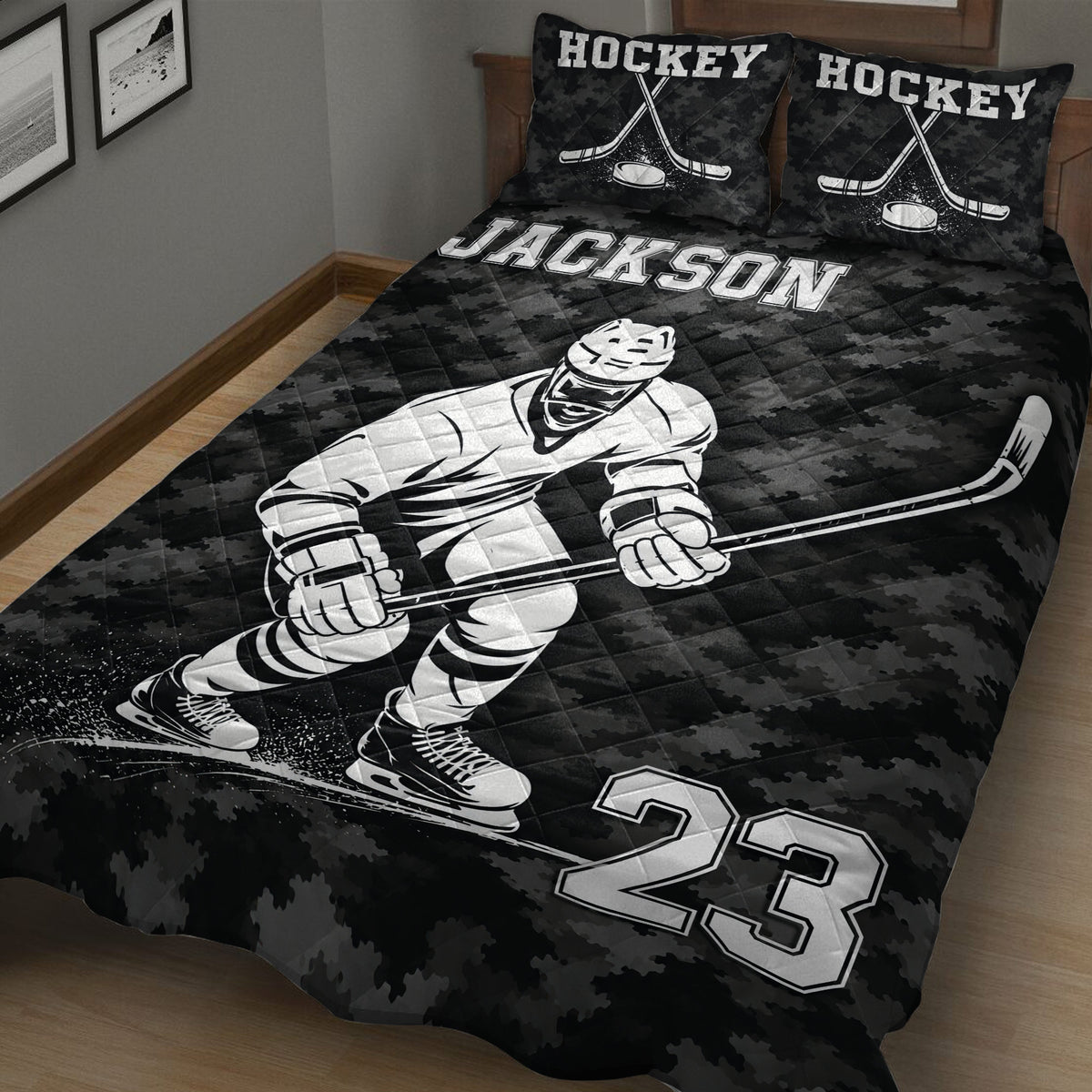 Close bedroom view of a black hockey quilt blanket featuring a helmeted player, stick, skates, puck, and sports graphics