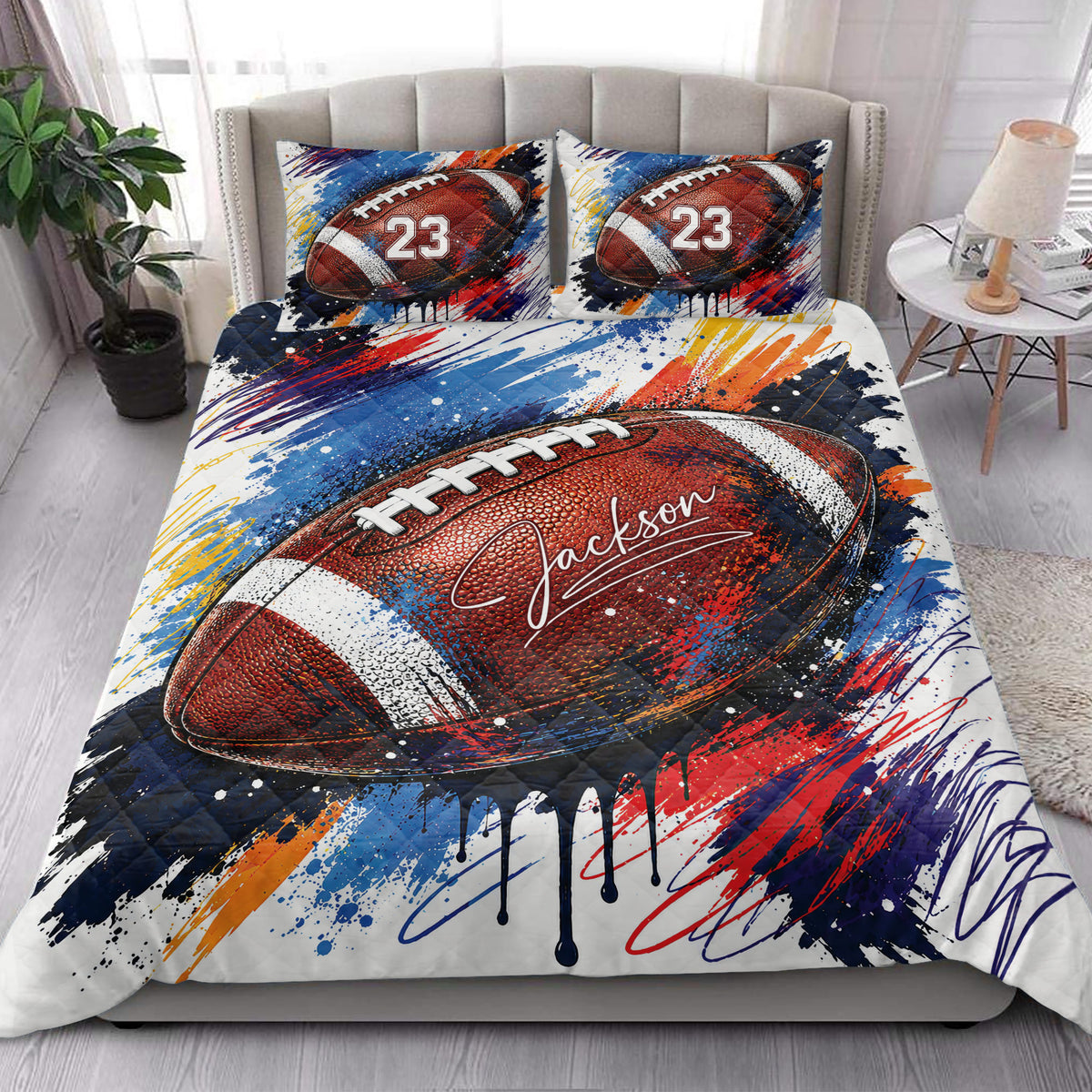 American football quilt blanket styled on a bedroom bed with colorful sports artwork and matching design pillows
