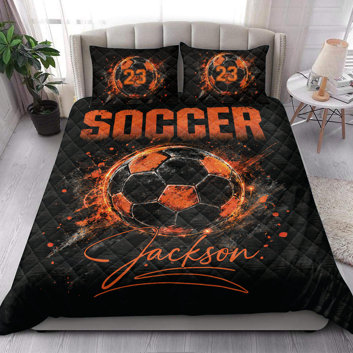 Black and orange soccer quilt styled on a bedroom bed with matching soccer artwork
