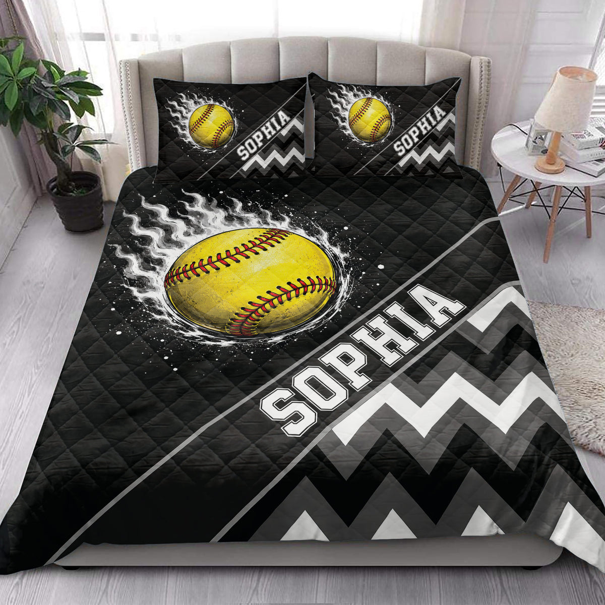 Black softball quilt blanket styled on a bedroom bed with bold yellow softball and geometric artwork