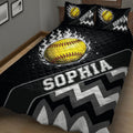 Close bedroom view of a black softball quilt with yellow softball artwork and gray zigzag accents