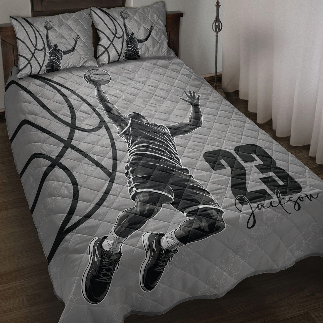 Basketball quilt blanket displayed on a bed with grayscale player artwork and oversized basketball graphics
