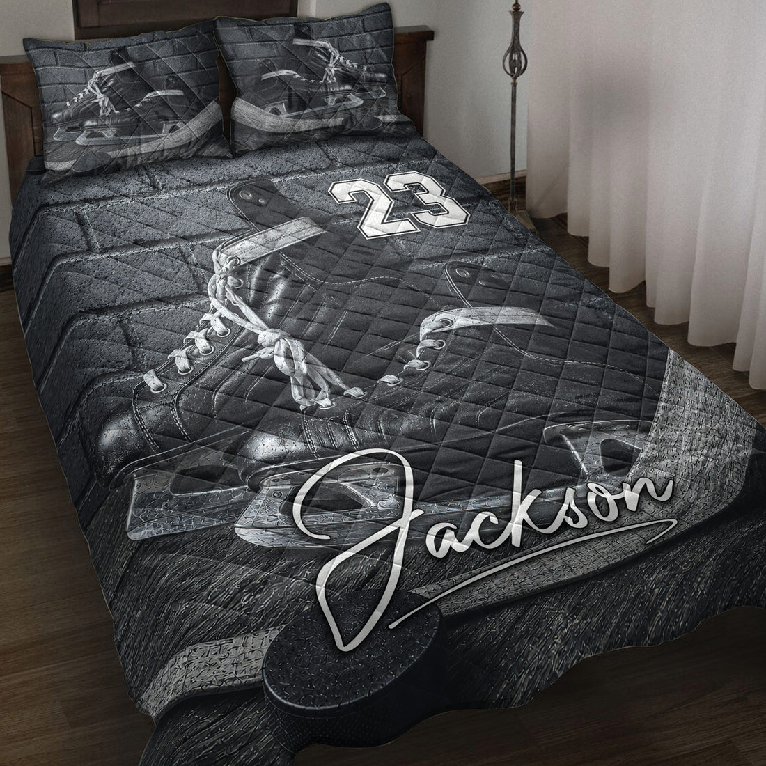 Black-and-gray hockey quilt blanket displayed on a bed with ice skates, pucks, and bold sports artwork