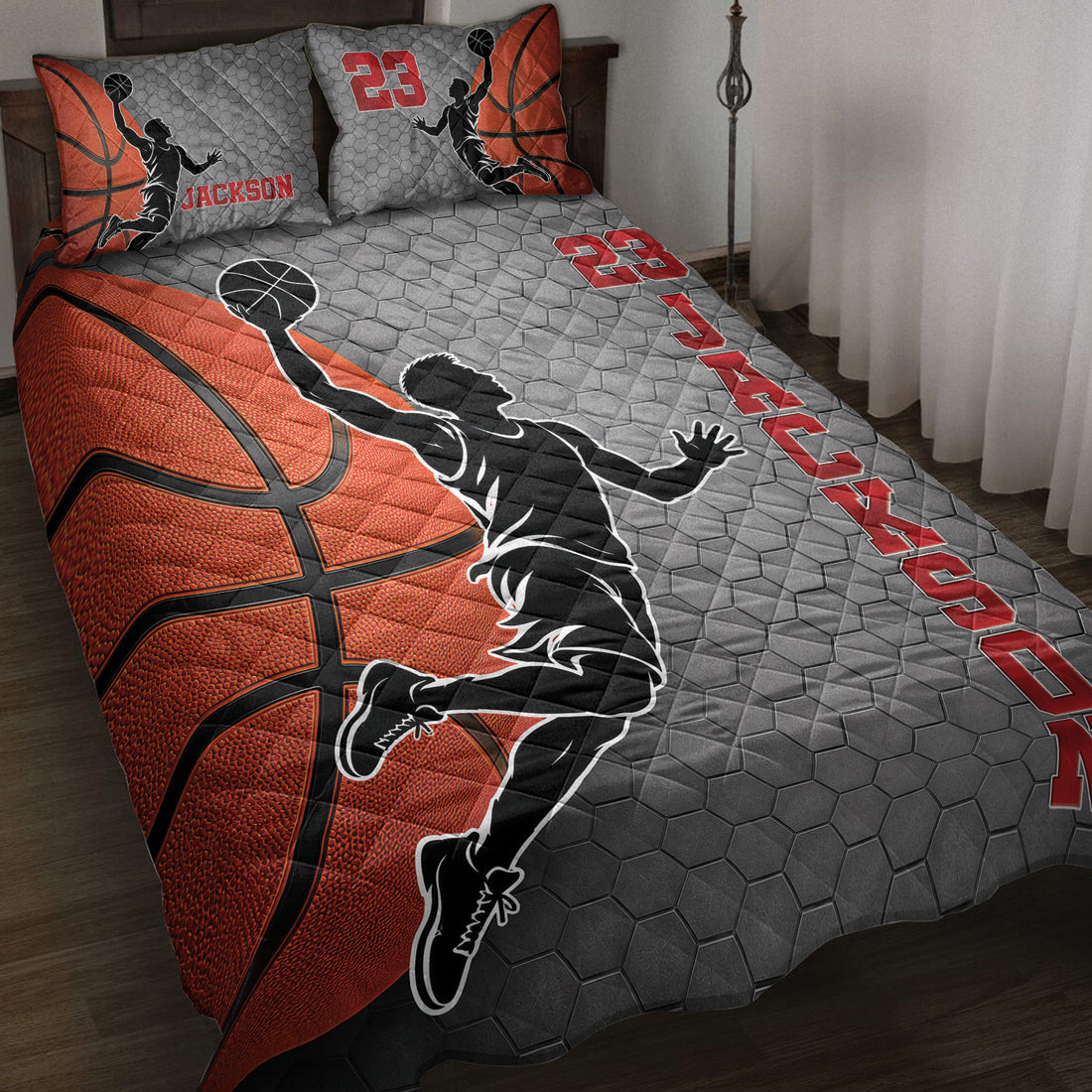 Basketball quilt blanket displayed on a bed with orange basketballs, player silhouettes, and red accents