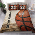 Basketball quilt bedding styled in a bright bedroom with bold orange basketball artwork