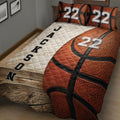 Close bedroom view of basketball quilt blanket with textured ball artwork and contrasting white panel
