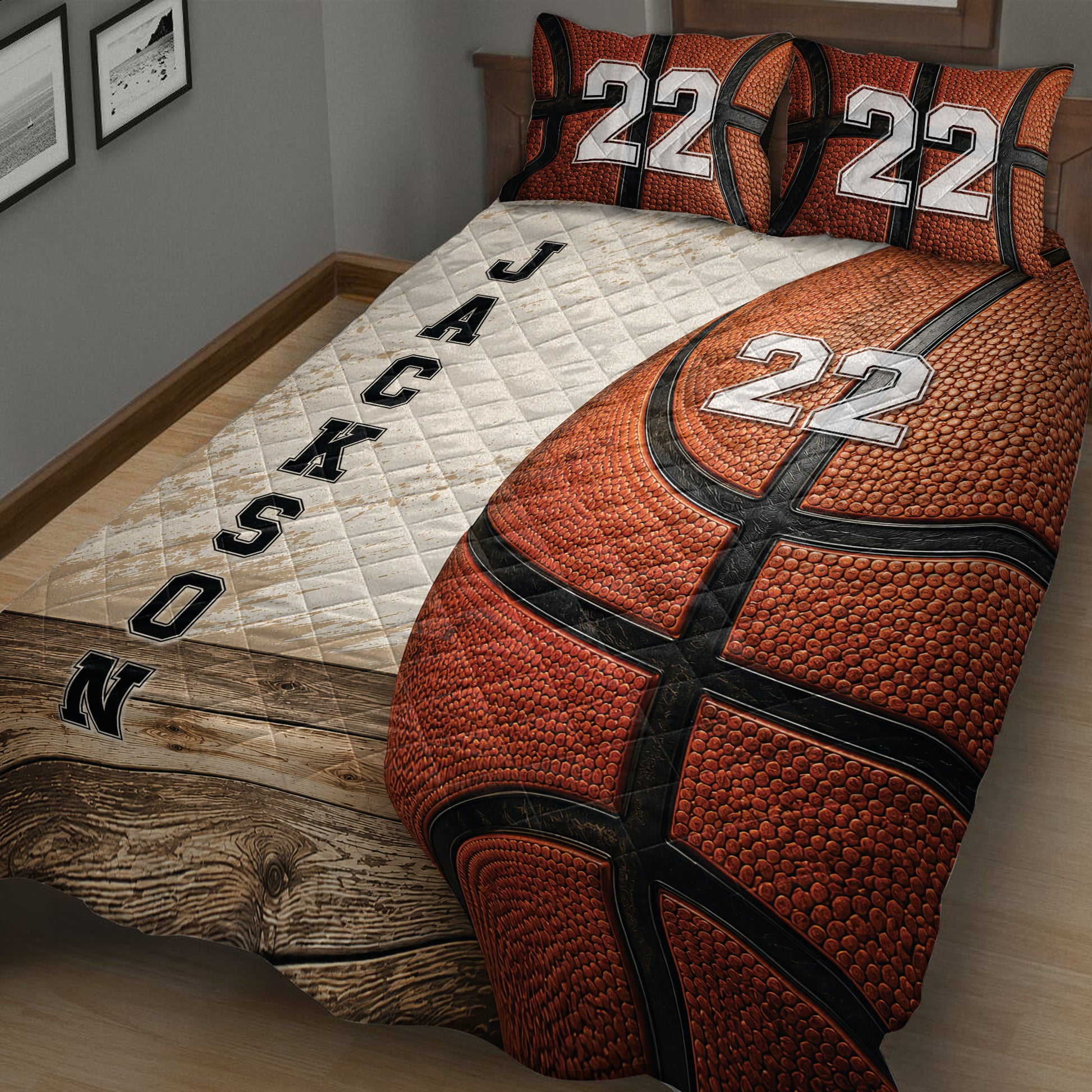 Close bedroom view of basketball quilt blanket with textured ball artwork and contrasting white panel