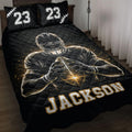Black football quilt blanket displayed on a bed with player artwork and gold-accented sports graphics