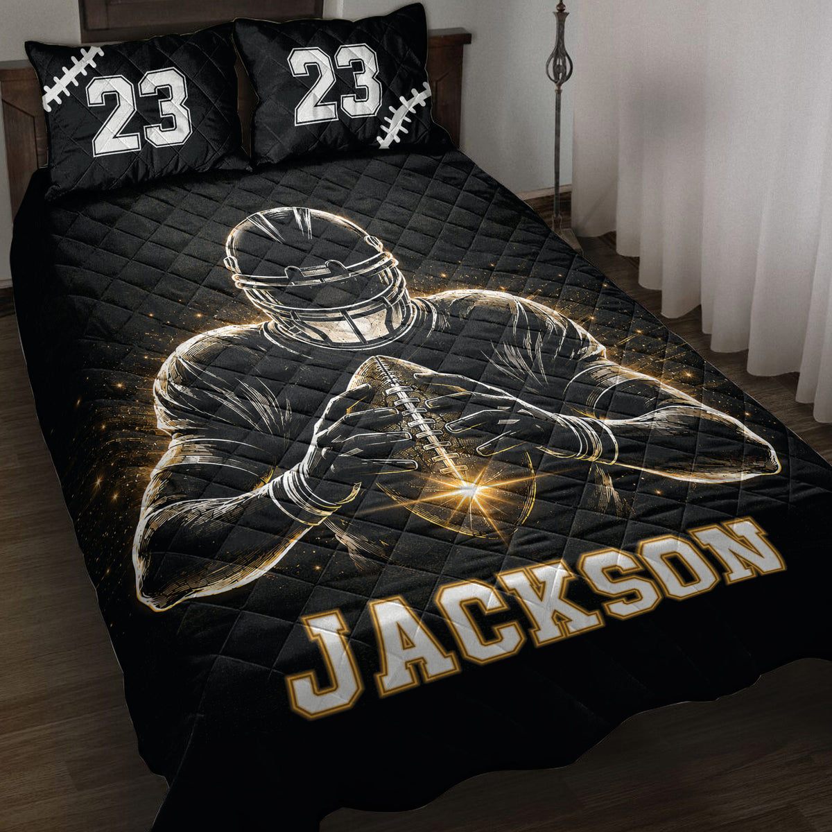 Black football quilt blanket displayed on a bed with player artwork and gold-accented sports graphics