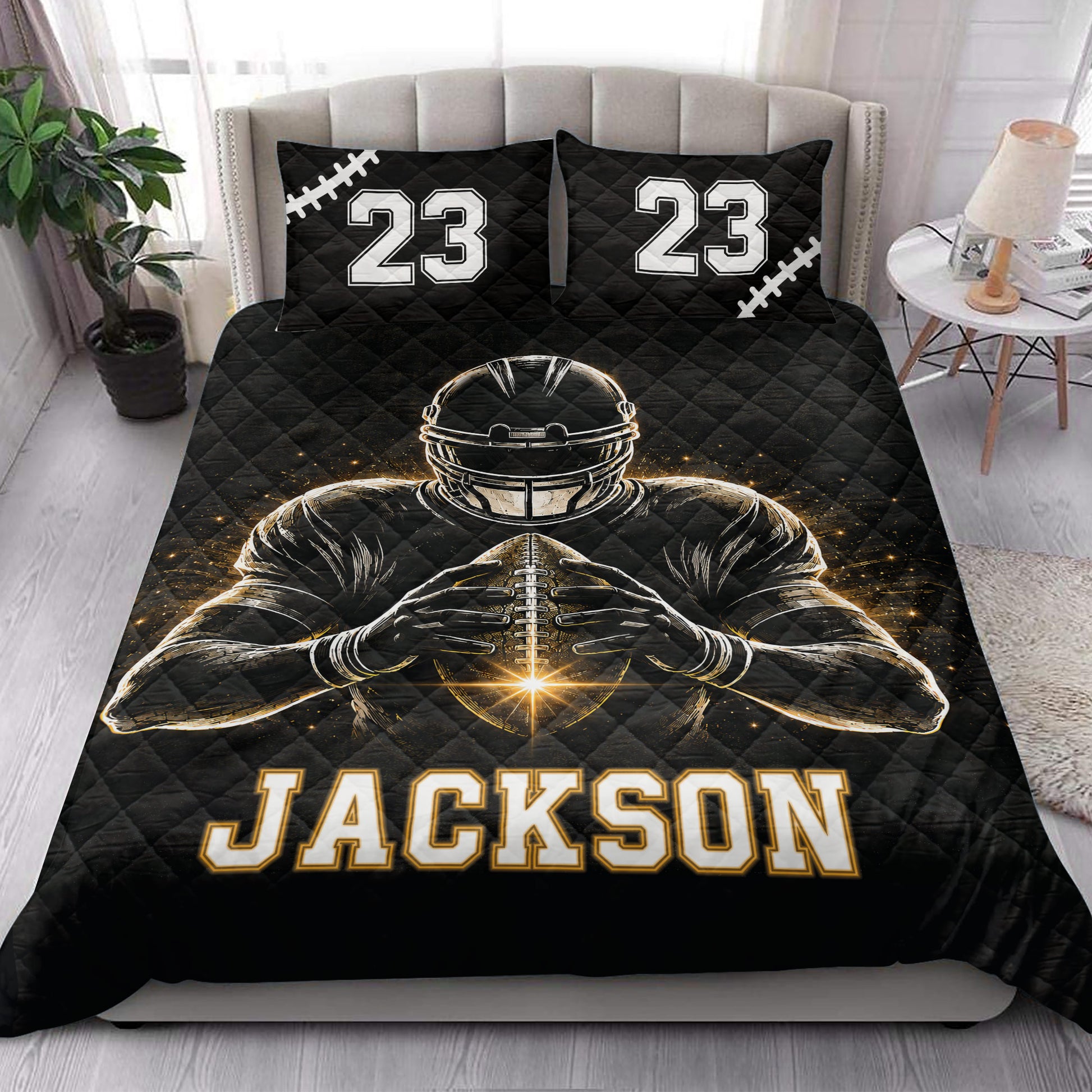 Black football quilt blanket styled on a bedroom bed with bold player artwork and sports-themed pillows