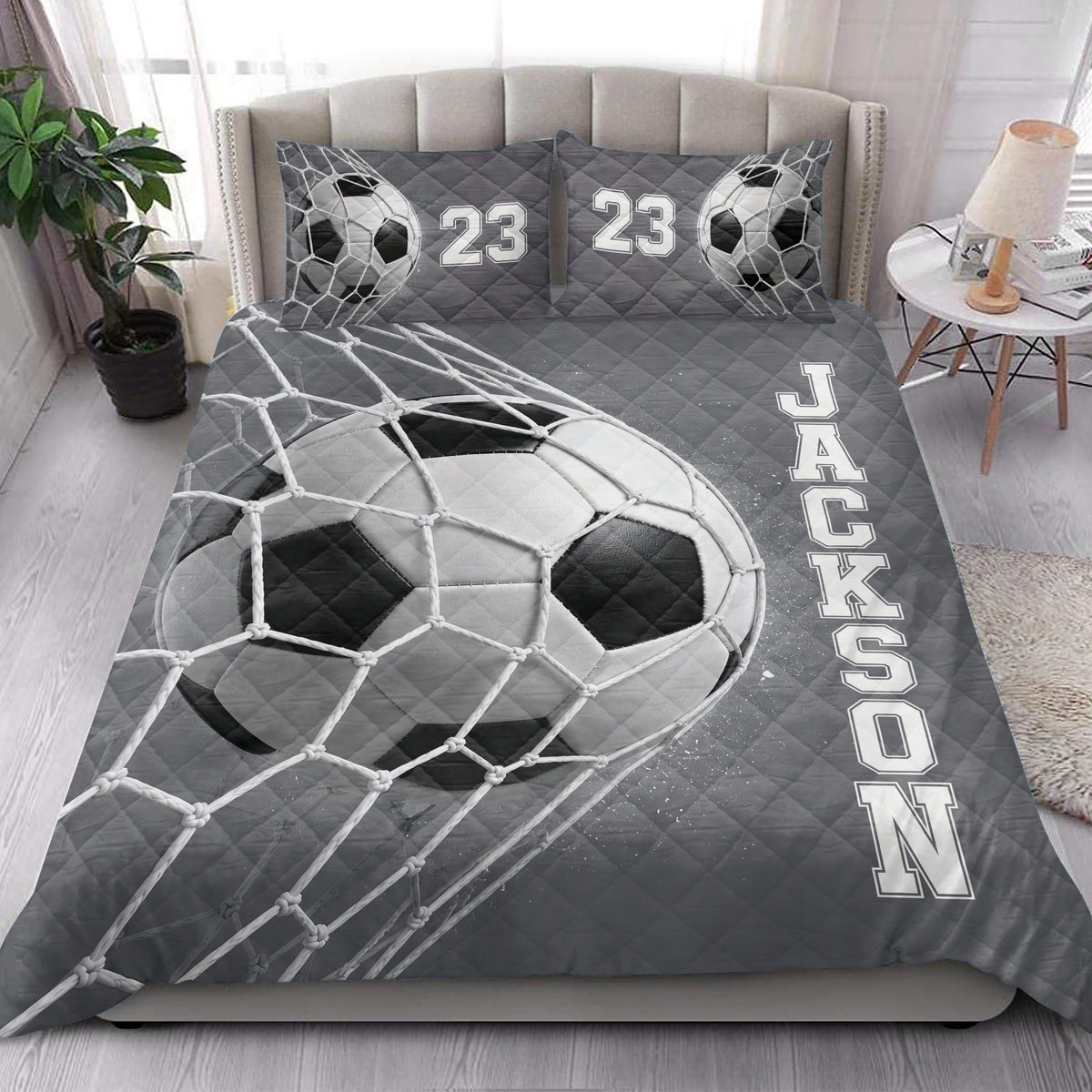 Soccer quilt blanket styled on a modern bed with large soccer ball and goal net artwork