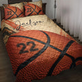 Basketball quilt blanket displayed on a bed with bold orange basketball artwork and matching sports pillows