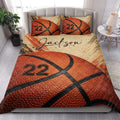 Basketball quilt bedding styled in a bright bedroom with orange basketball artwork