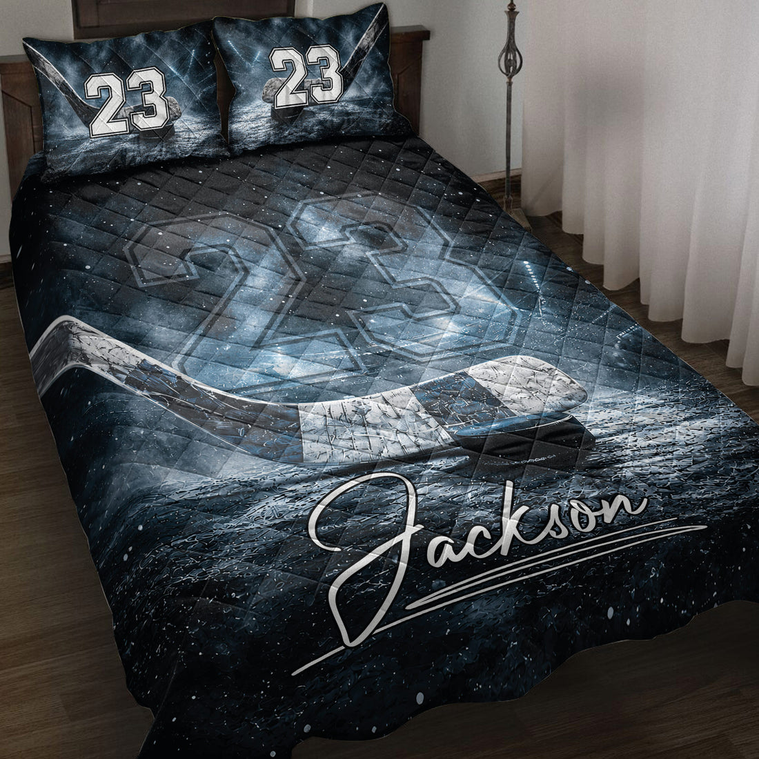 Hockey quilt blanket displayed on a bed with icy rink artwork, hockey stick, puck, and dark blue details