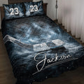Hockey quilt blanket displayed on a bed with icy rink artwork, hockey stick, puck, and dark blue details