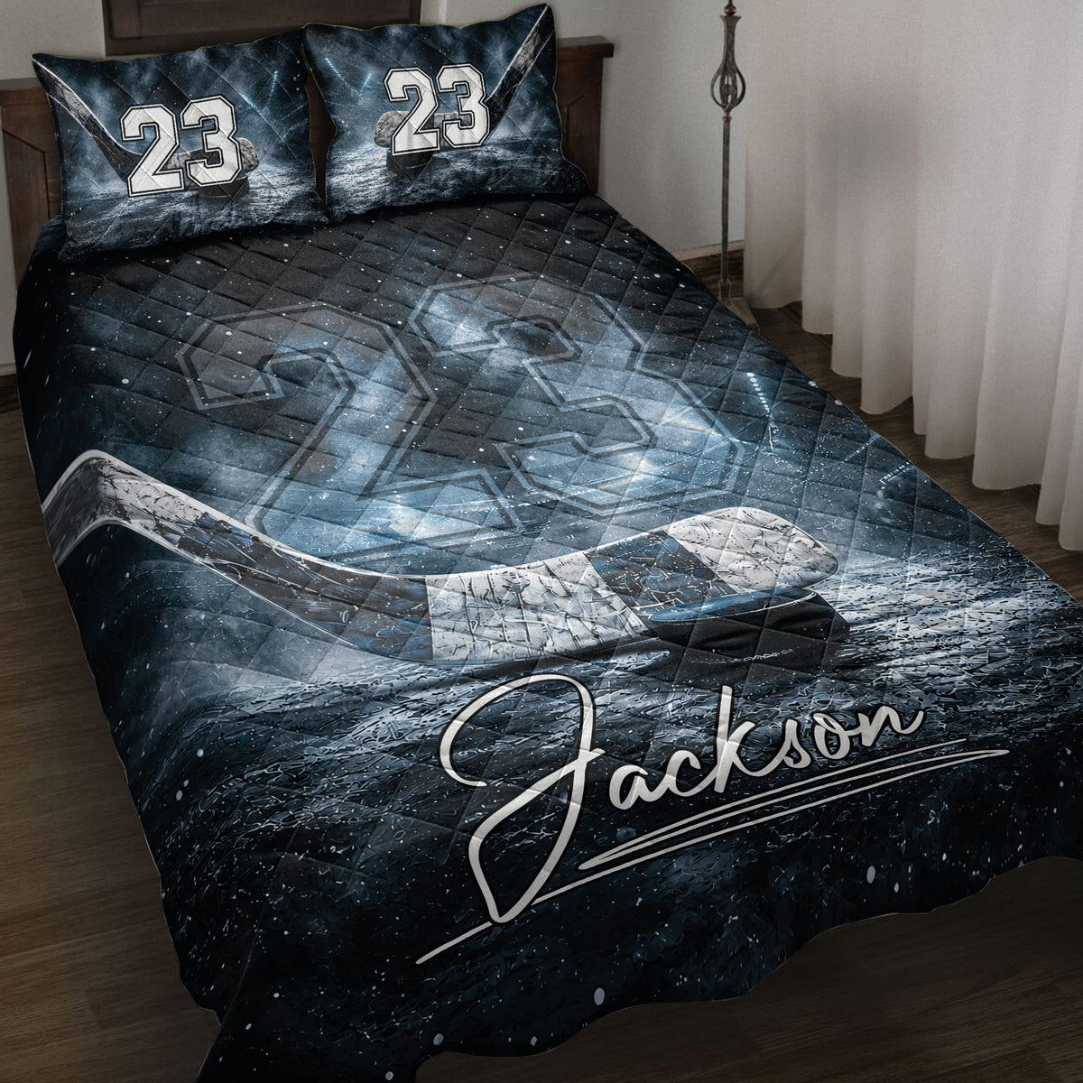 Hockey quilt blanket displayed on a bed with icy rink artwork, hockey stick, puck, and dark blue details