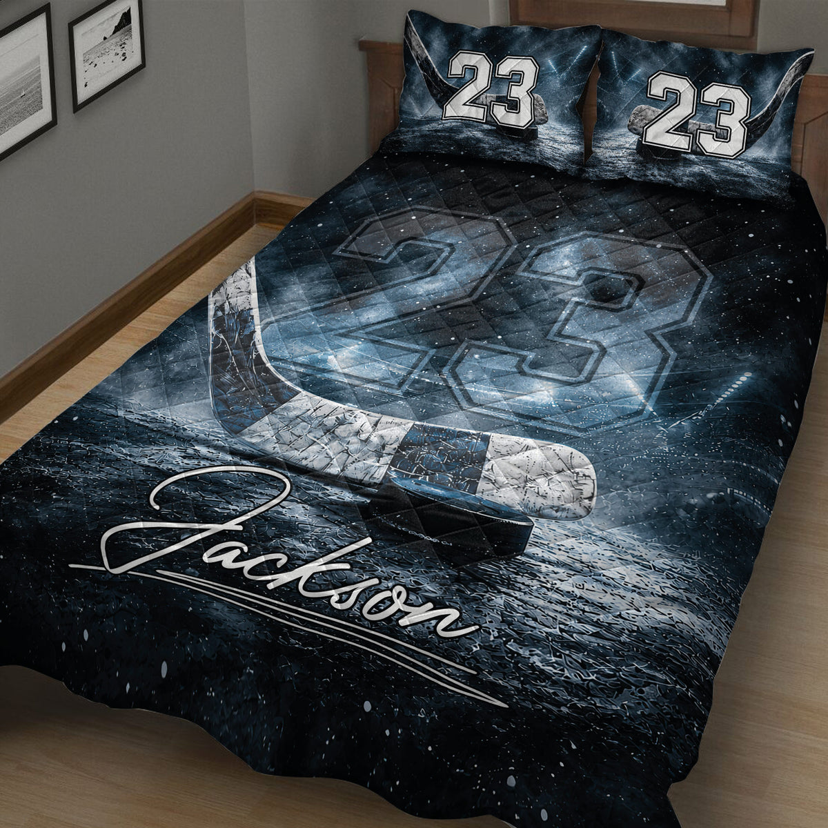 Close bedroom view of a dark blue hockey quilt blanket featuring icy rink textures, hockey stick, and puck