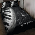 Black and white piano keys quilt blanket with musical notes and treble clef artwork on a bed