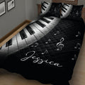 Black piano keys and musical notes quilt blanket presented in a cozy bedroom setting