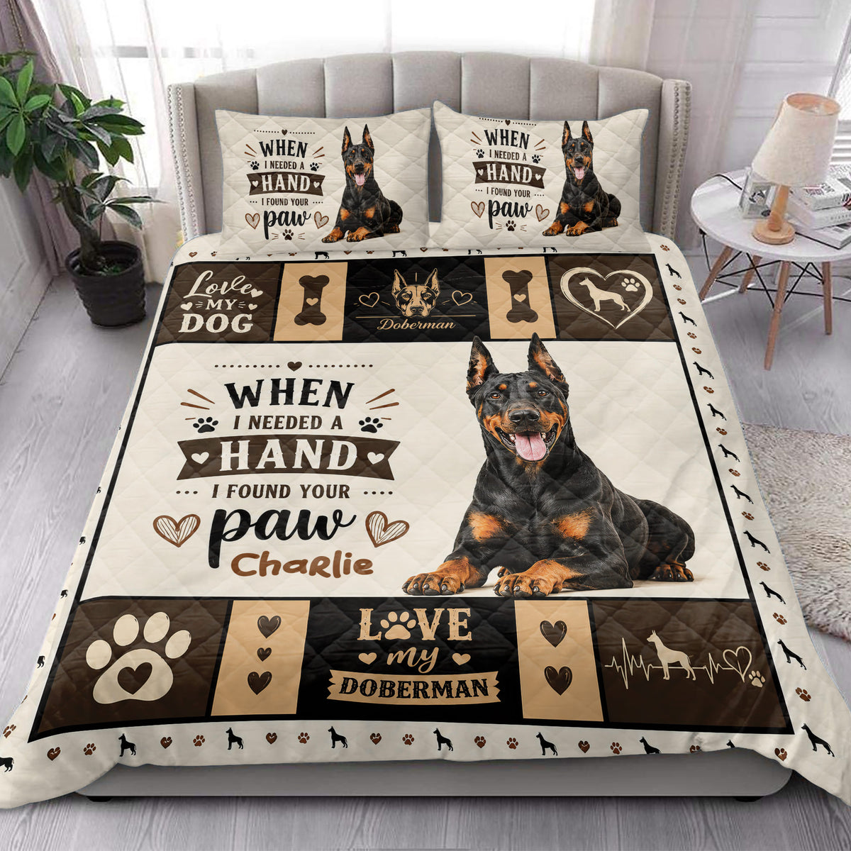 Doberman quilt bedding styled in a bright bedroom with a large seated dog portrait and paw print border