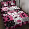 Pink and black cheerleading quilt blanket displayed on a bed with cheerleader silhouettes and pom-poms