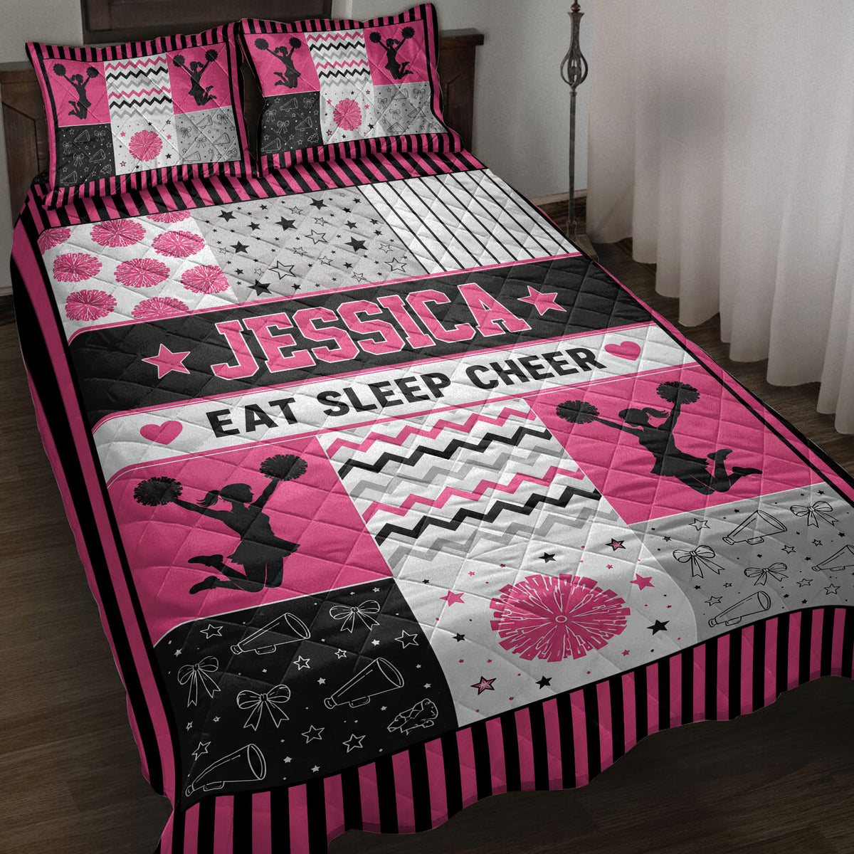 Pink and black cheerleading quilt blanket displayed on a bed with cheerleader silhouettes and pom-poms