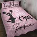 Pink cheerleading quilt blanket displayed on a bed with pom-pom cheerleader silhouettes and bold cheer artwork