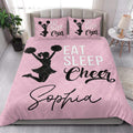 Pink cheerleading quilt blanket styled on a bright bedroom bed with matching cheer-themed pillow designs