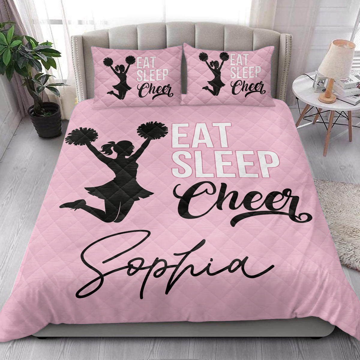 Pink cheerleading quilt blanket styled on a bright bedroom bed with matching cheer-themed pillow designs