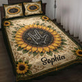 Sign language hand gesture framed by golden sunflowers on a dark green quilt displayed on a bed