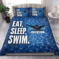 Blue swimmer quilt blanket styled on a bed with bold pool-water artwork and bedroom decor