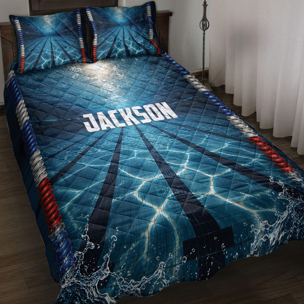 Blue swimming pool lane quilt bedding set styled on a bed with wave splashes and red, white, and blue accents