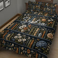 Close bedroom view of a dark book-themed quilt with flowers, books, and decorative vases