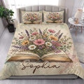 Bedroom view of a book-themed quilt blanket with an open book and abundant pink, purple, and orange flowers