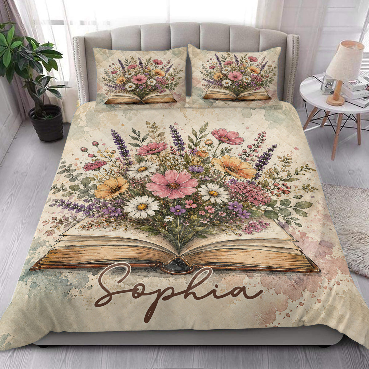 Bedroom view of a book-themed quilt blanket with an open book and abundant pink, purple, and orange flowers