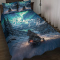 Snowmobile quilt blanket on a bed with snowy mountains, evergreen trees, aurora colors, and winter riding artwork