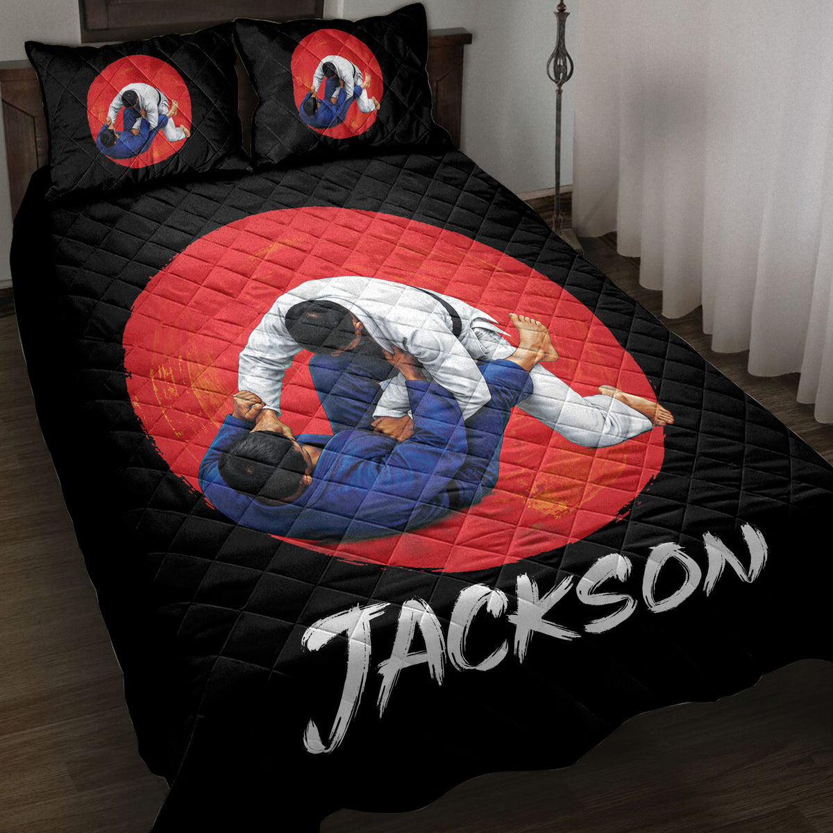 Black jiu jitsu quilt blanket displayed on a bed with grappling artwork in a red circle