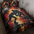 Wrestling quilt blanket displayed on a bed with grappling silhouettes and bold red, black, and gold artwork