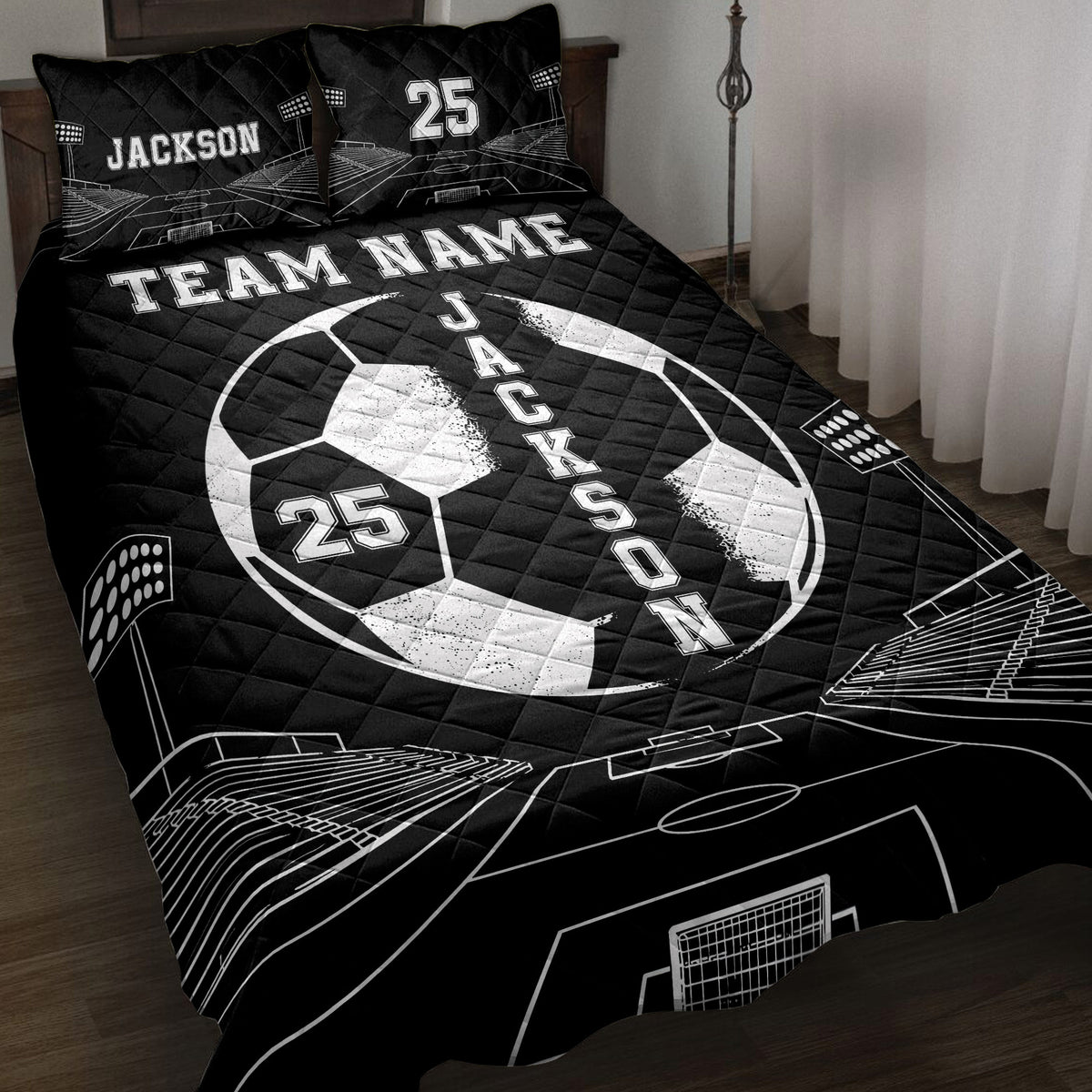 Black soccer quilt blanket displayed on a bed with bold white ball, goal, and stadium artwork