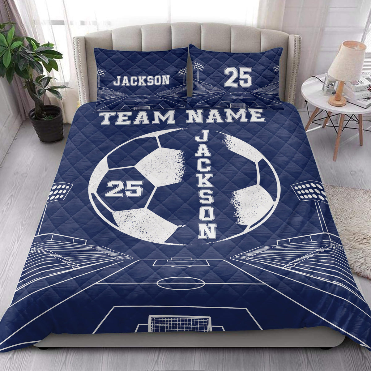 Navy soccer quilt bedding set styled across a bedroom with a large soccer ball and stadium field design