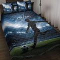 Blue soccer quilt blanket displayed on a bed with player silhouettes and stadium field artwork