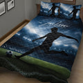 Close bedroom view of a blue soccer quilt with player silhouette, stadium, and field design