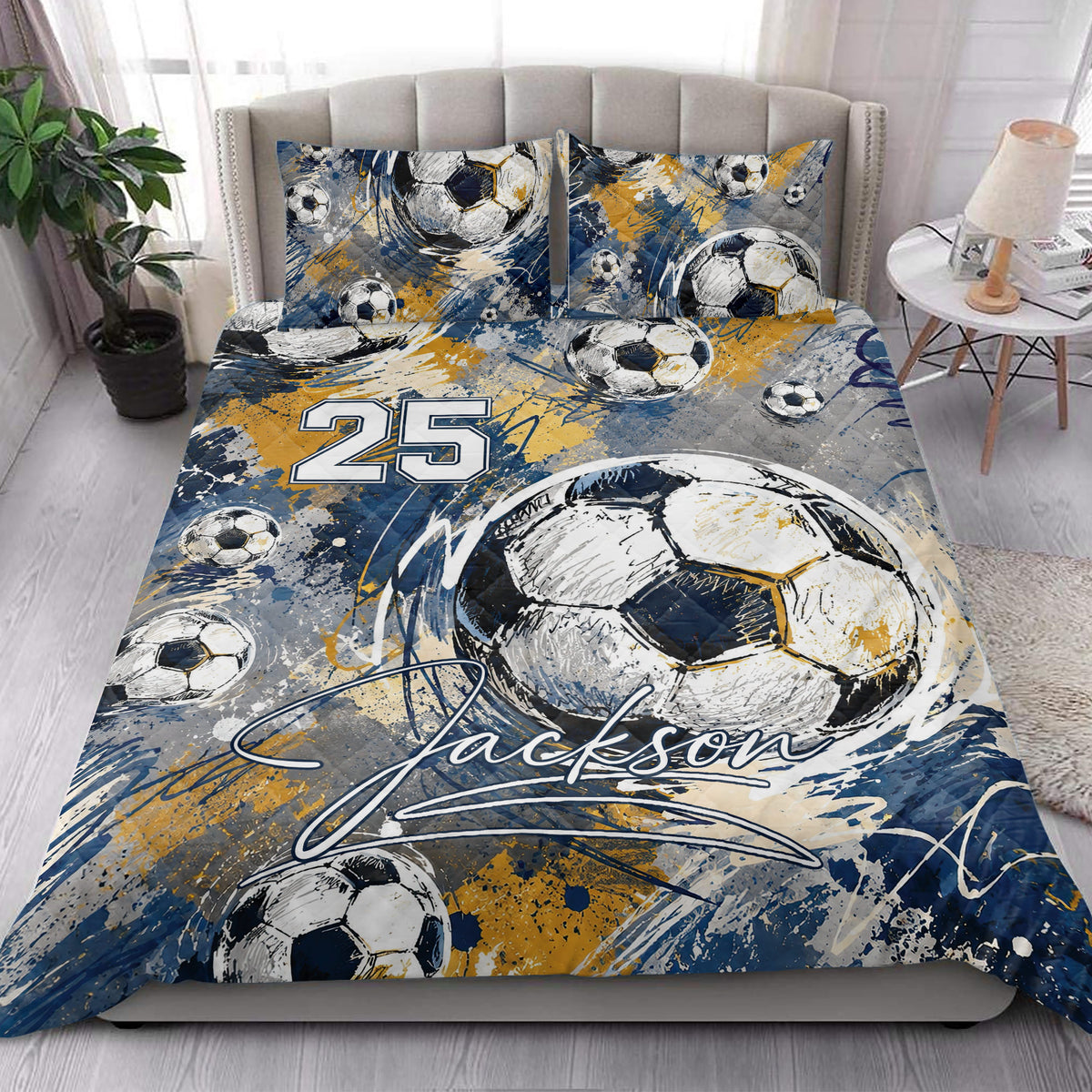 Soccer quilt blanket styled on a bedroom bed with oversized ball artwork and blue gold accents