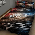 Close bedroom view of a racing quilt blanket featuring a sweeping track, checkered flags, and red, black, and blue accents